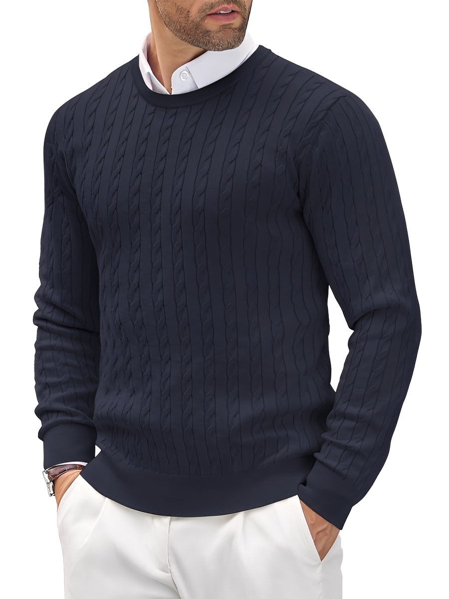 Man wearing a navy cable knit sweater with a white shirt and pants on a white background