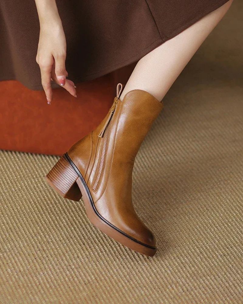 Brown ankle boot worn by a person on a textured surface