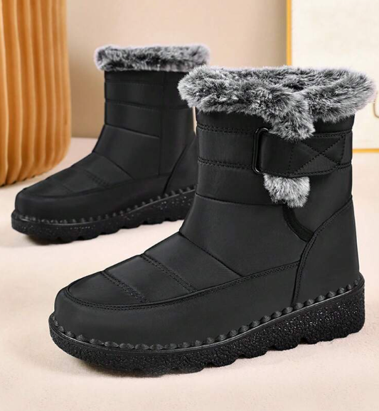 Black winter boots with fur trim on a beige background