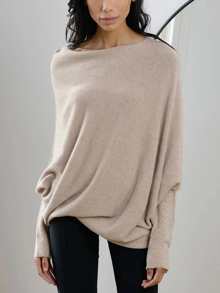 Woman wearing a beige sweater against a plain background