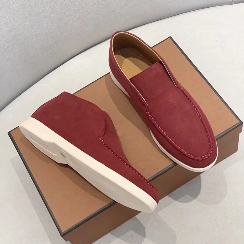 Red loafer shoes on a brown shoe box with a gray background