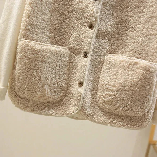 Close-up of a beige sherpa jacket with button details on a light background