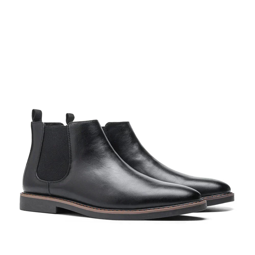 Pair of black leather Chelsea boots on a white background