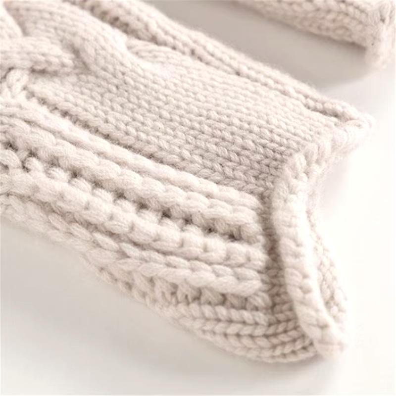Close-up of a beige knitted blanket on a white background