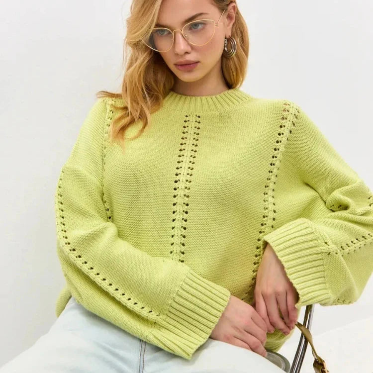 Woman wearing a light green sweater with a white background