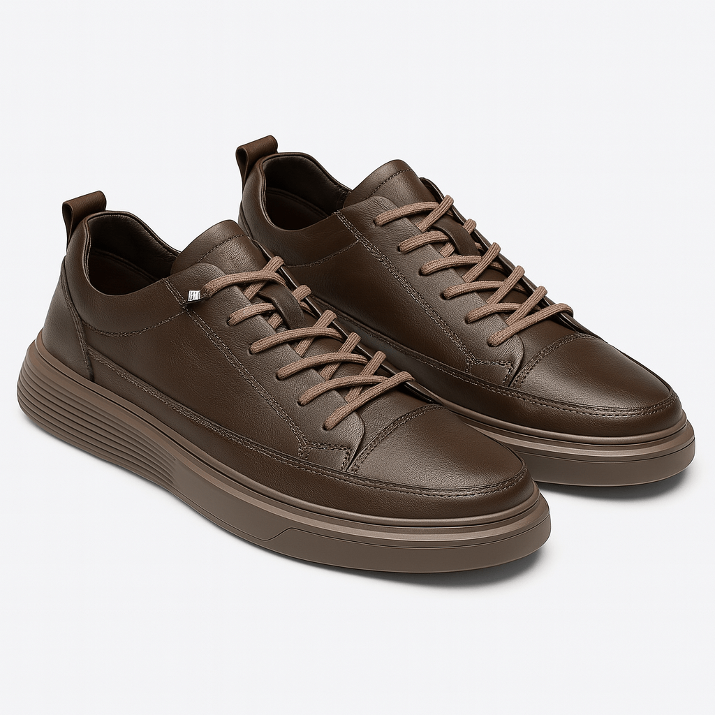 Pair of brown leather sneakers on a light gray background