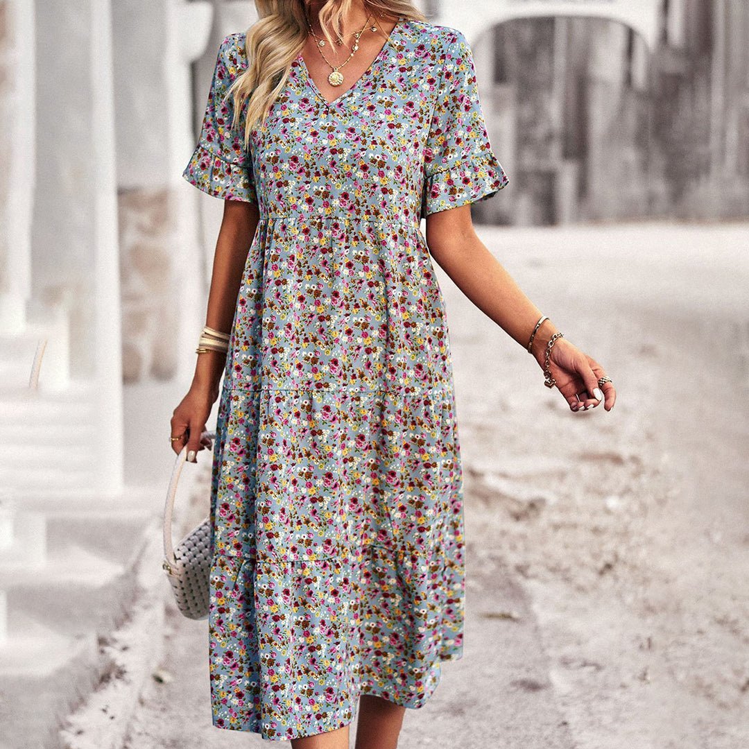 Woman wearing a floral dress walking on a street.