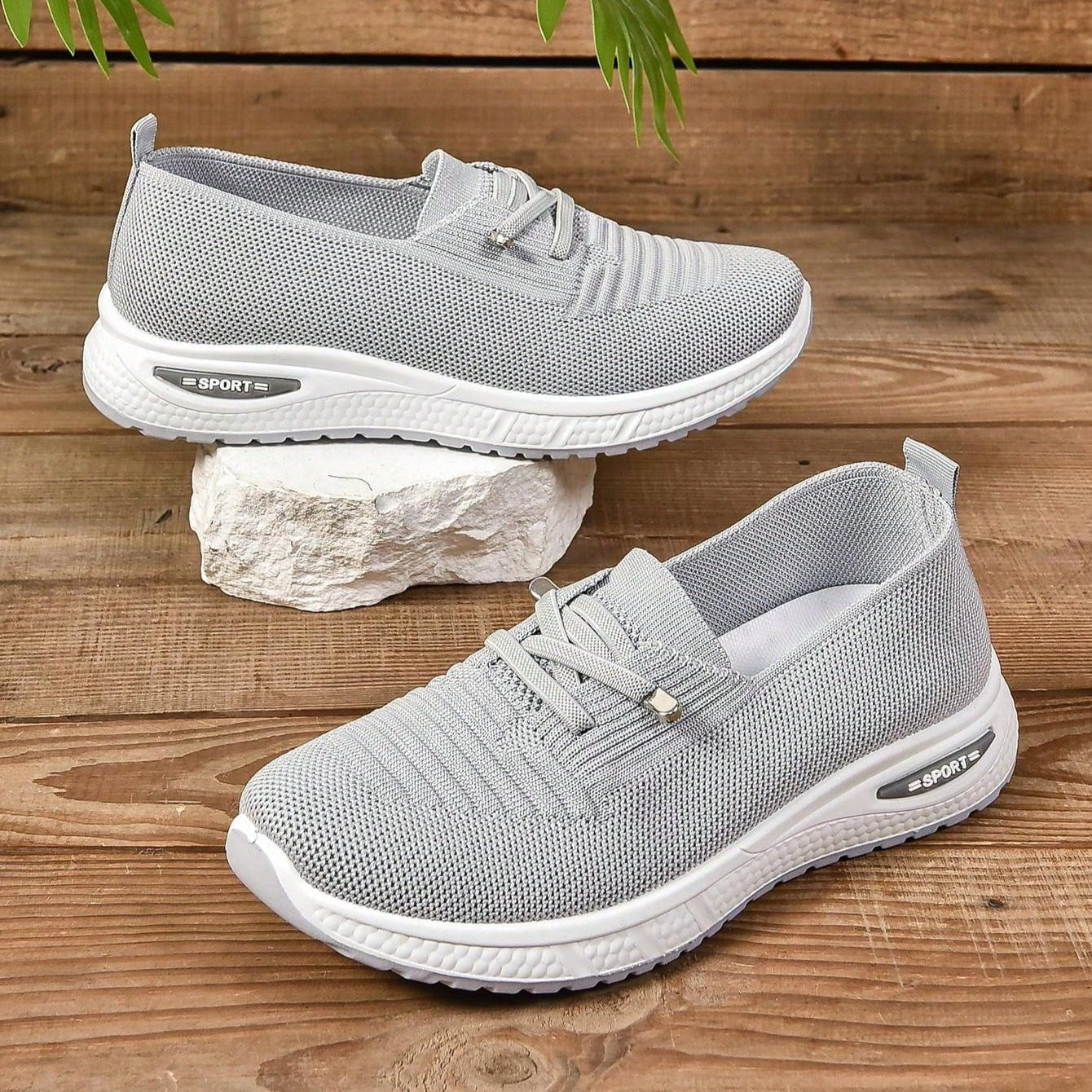 Gray sneakers with white soles on a wooden surface