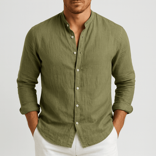 Man wearing a green button-up shirt with rolled-up sleeves on a light gray background