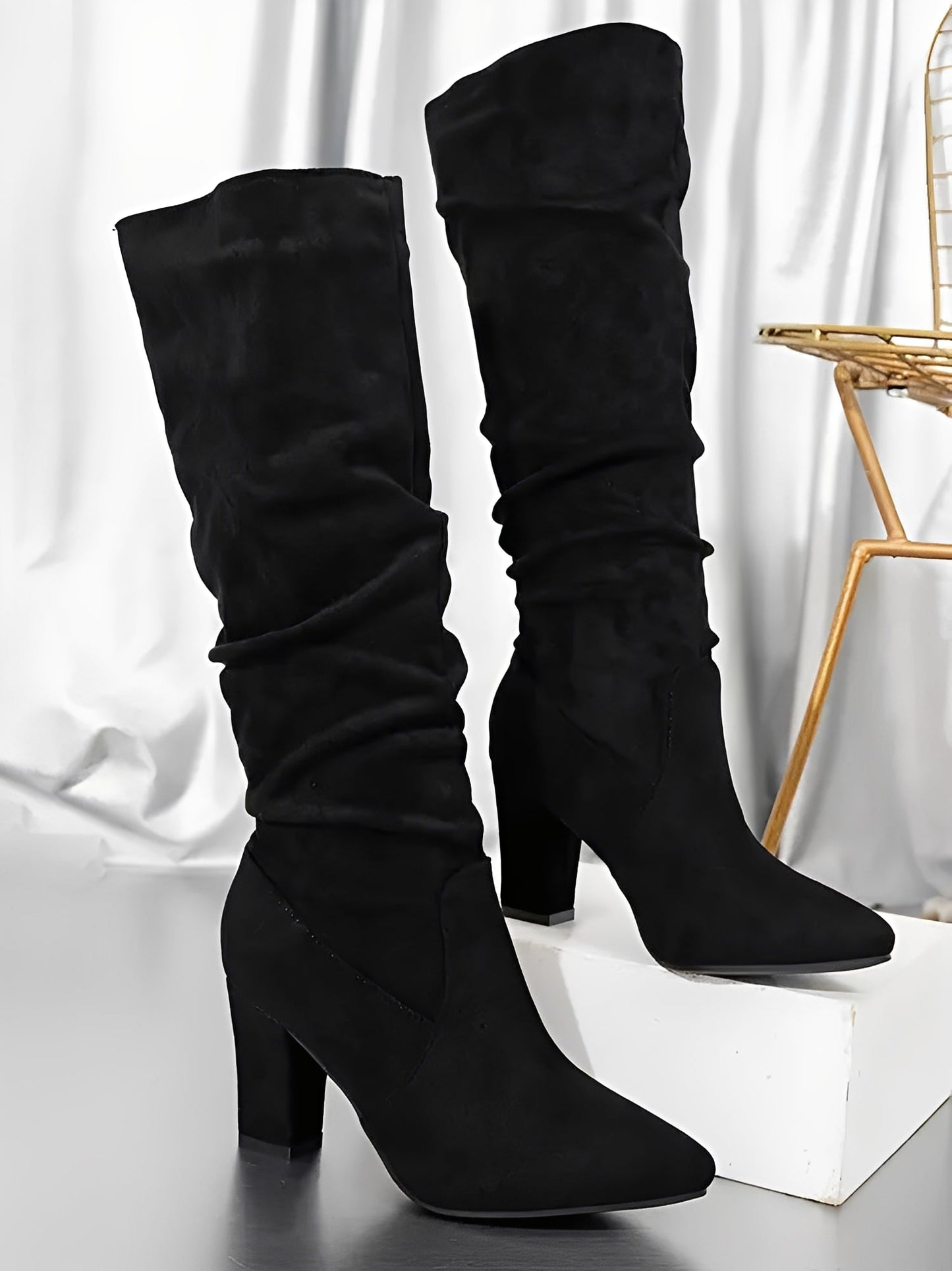 Black knee-high boots on a white background