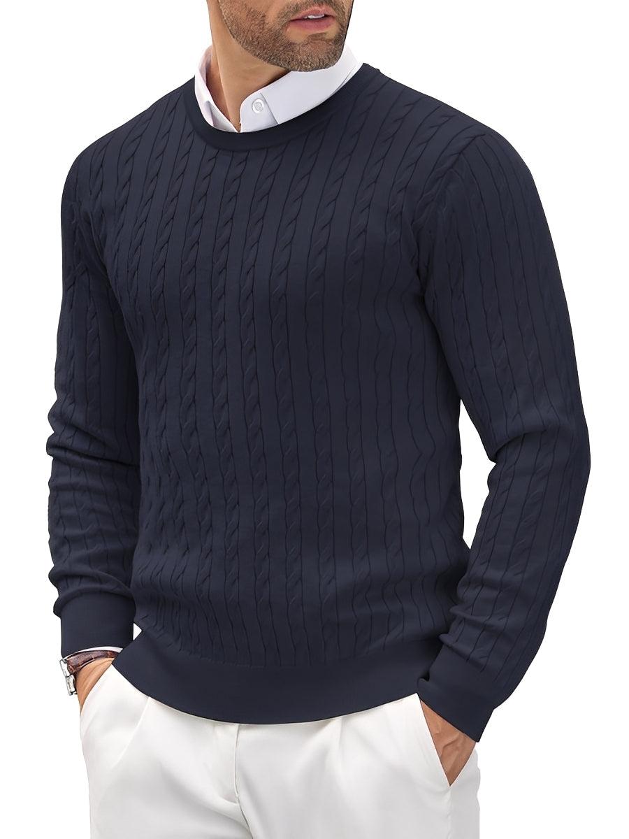 Man wearing a navy cable knit sweater with a white shirt and pants on a white background