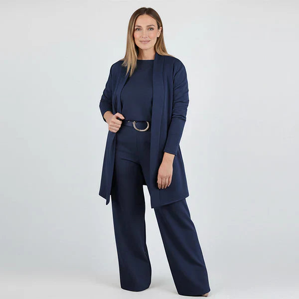 Woman wearing a navy blue outfit with a matching cardigan and pants on a white background