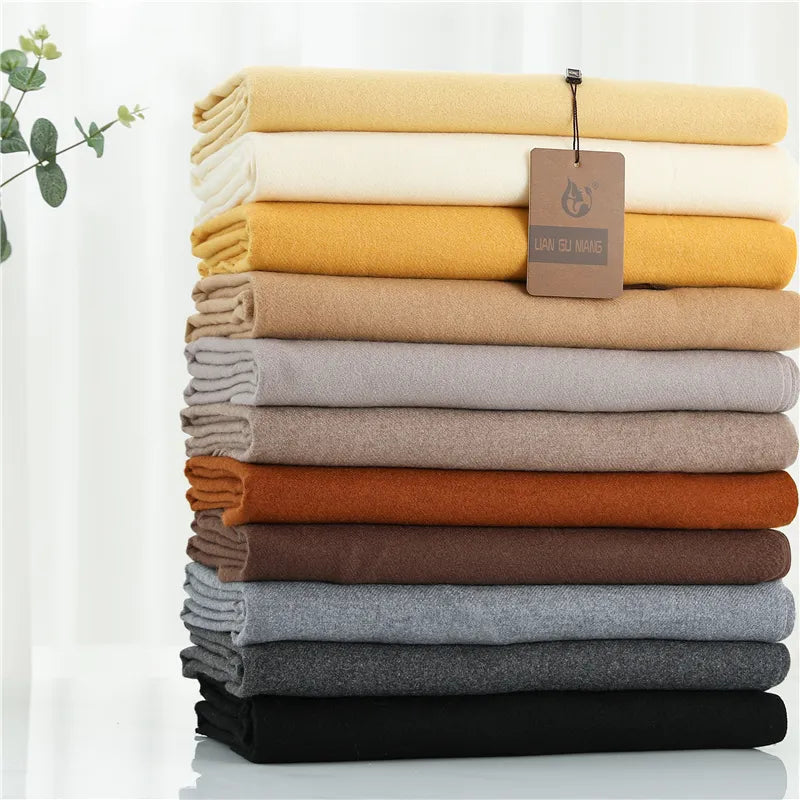 Stack of folded cloths in various colors with a visible brand tag on a white background.