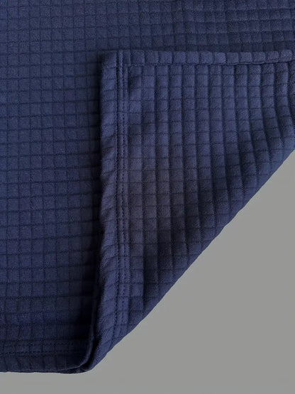 Navy blue textured blanket on a gray background