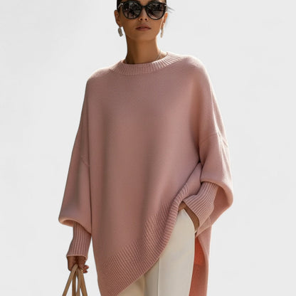 Woman wearing a pink poncho against a white background