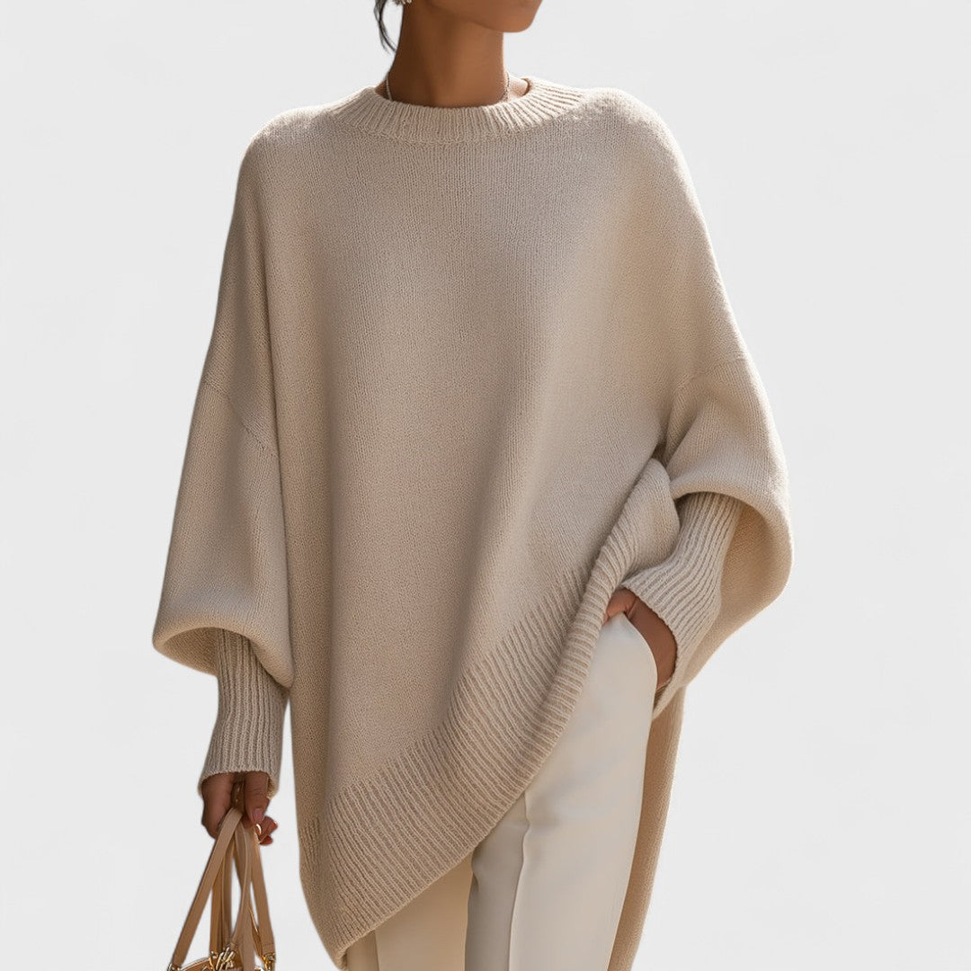 Beige poncho worn by a person on a light gray background