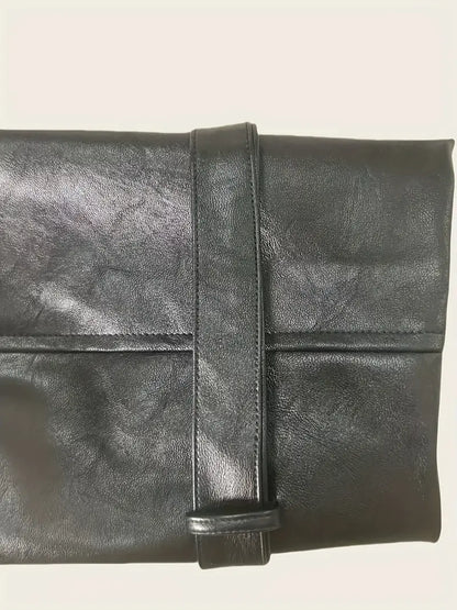 Black leather clutch bag on a light beige background