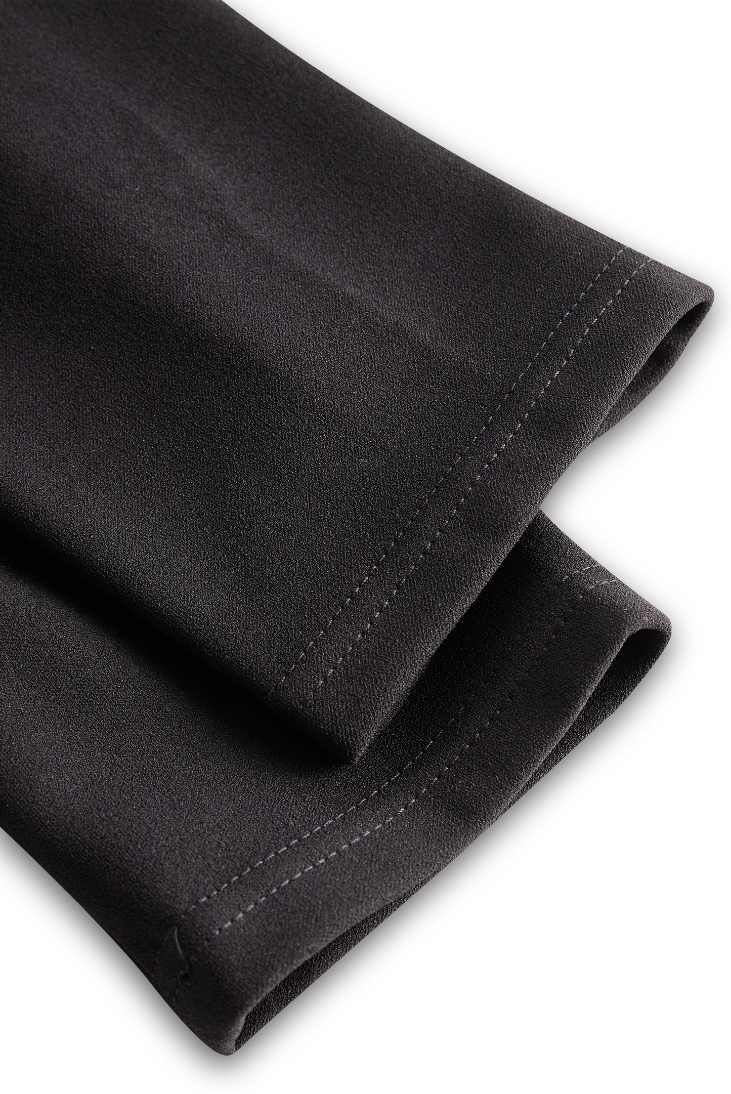 Close-up of black pants with a white background