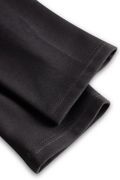 Close-up of black pants with a white background