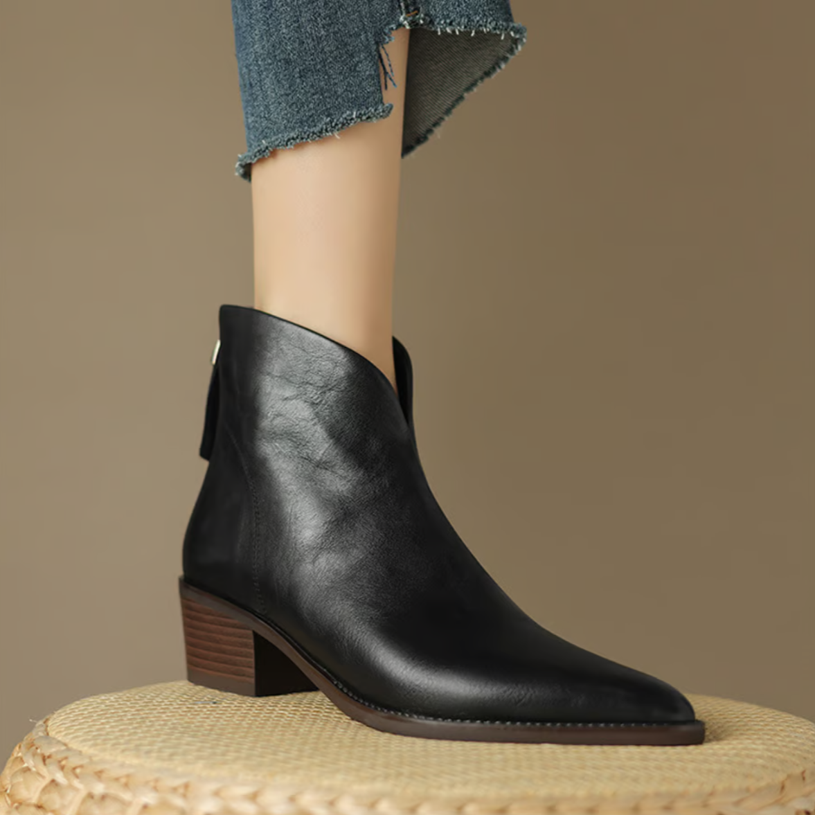 Black leather ankle boot on a neutral background