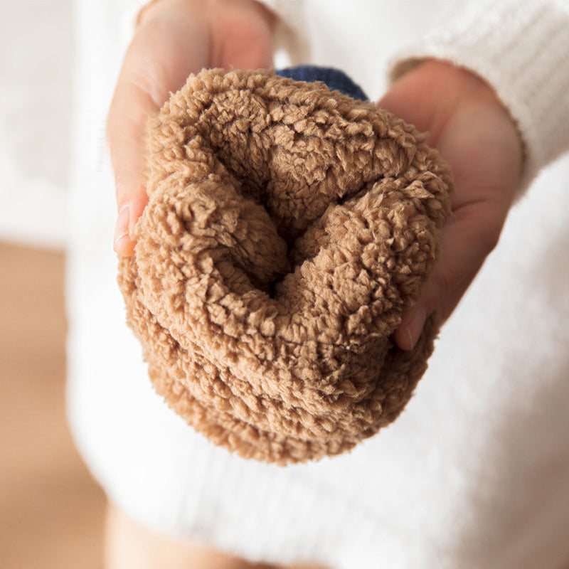 Close-up of a hand holding a brown textured ball against a blurred background