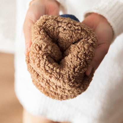 Close-up of a hand holding a brown textured ball against a blurred background