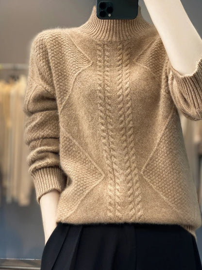 Beige knitted sweater with cable pattern on a mannequin against a blurred background