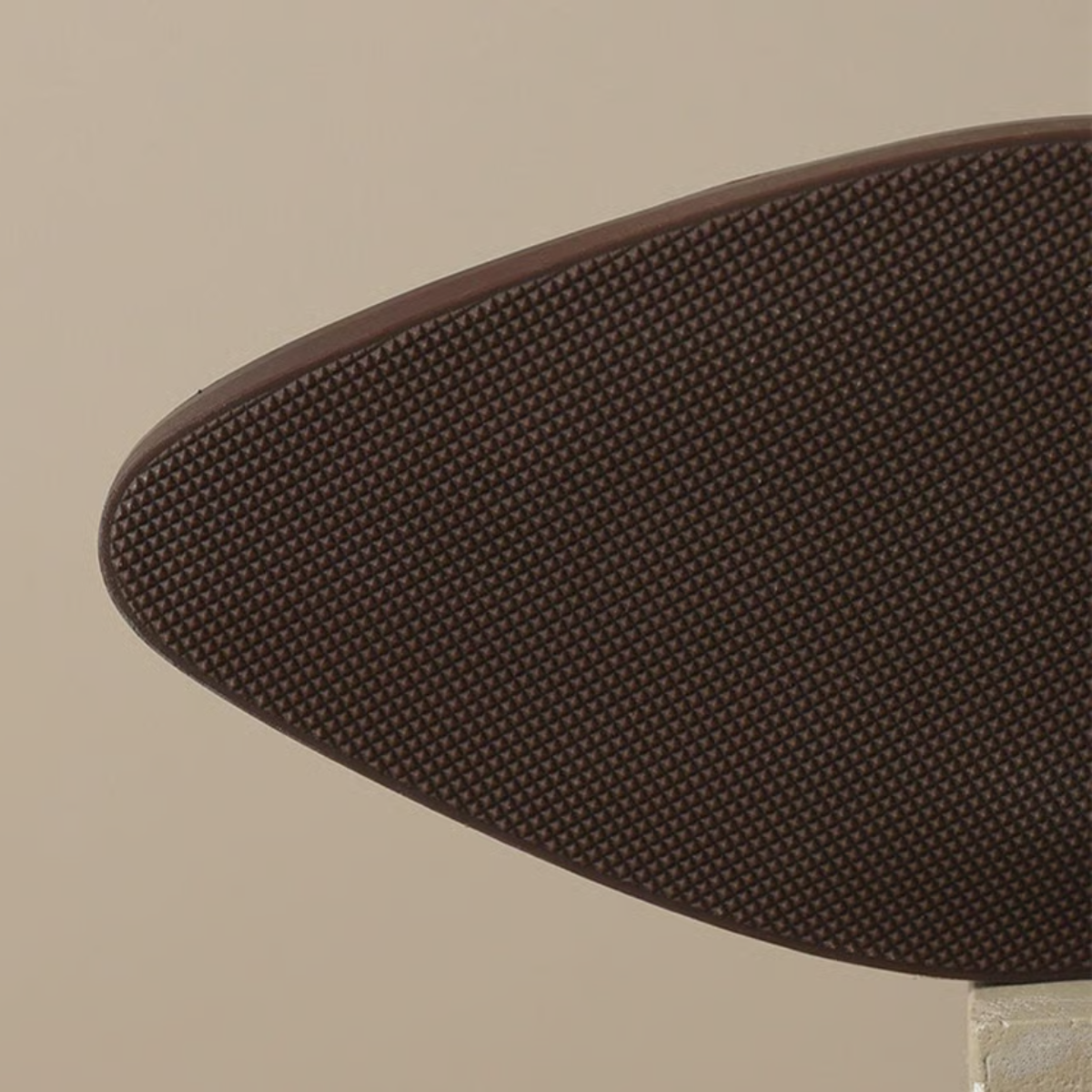 Close-up of a brown shoe sole on a beige background