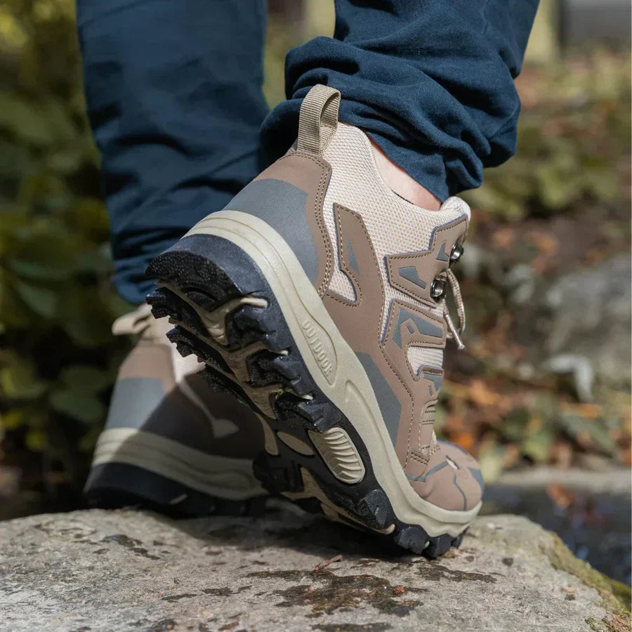 Person wearing brown hiking boots with a blurred natural background