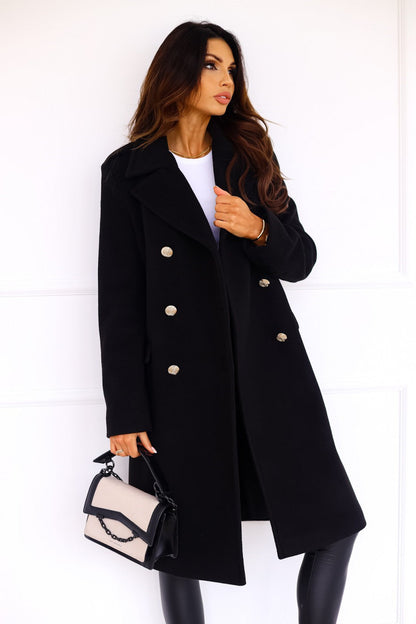 Woman wearing a black coat with white buttons against a white background