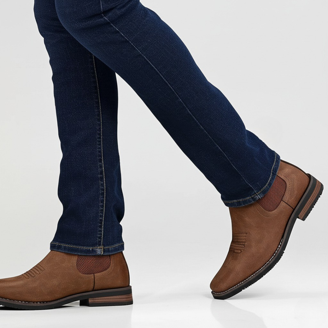Brown leather shoes worn with blue jeans on a white background