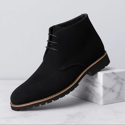 Black suede ankle boot on a light gray background