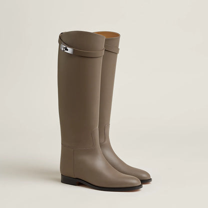 Pair of brown knee-high rubber boots on a beige background