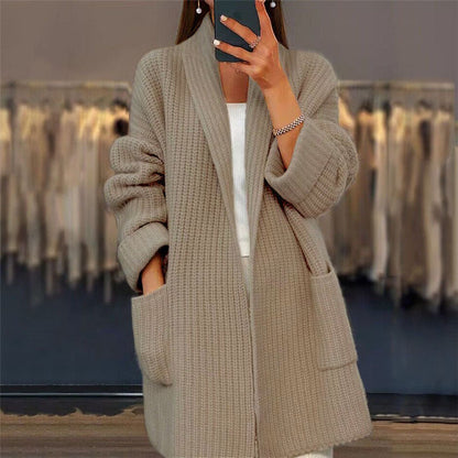Person wearing a beige knitted cardigan in a clothing store.