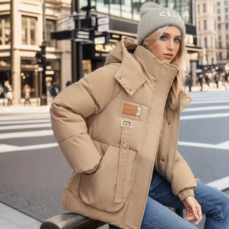Woman wearing a beige puffer jacket and gray beanie in an urban setting