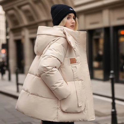Person wearing a beige puffer jacket on a city street