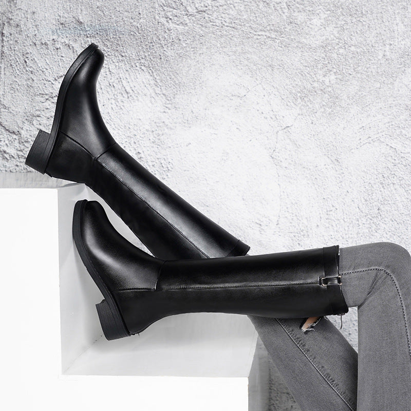 Black rain boots on a light gray surface