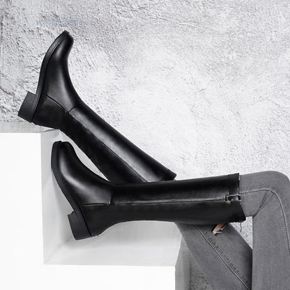 Black rain boots on a light gray surface