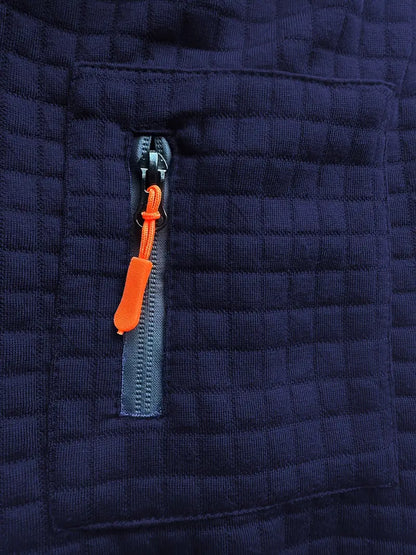 Close-up of a navy blue quilted jacket with an orange zipper