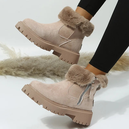 Beige winter boots with fur trim worn by a person on a light background
