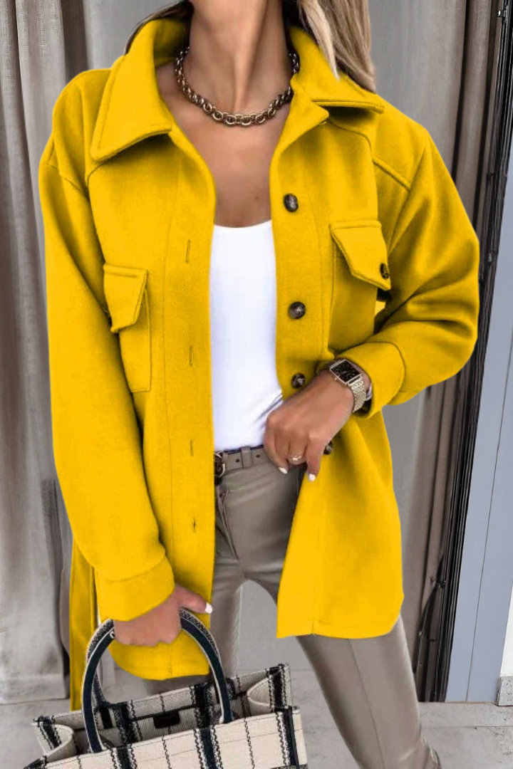 Person wearing a bright yellow coat with a neutral background
