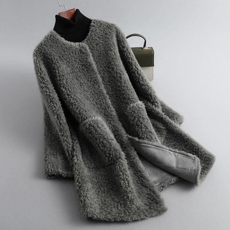 Gray fluffy coat on a hanger against a light gray background