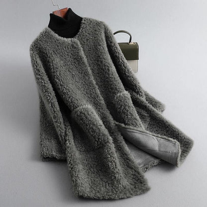 Gray fluffy coat on a hanger against a light gray background