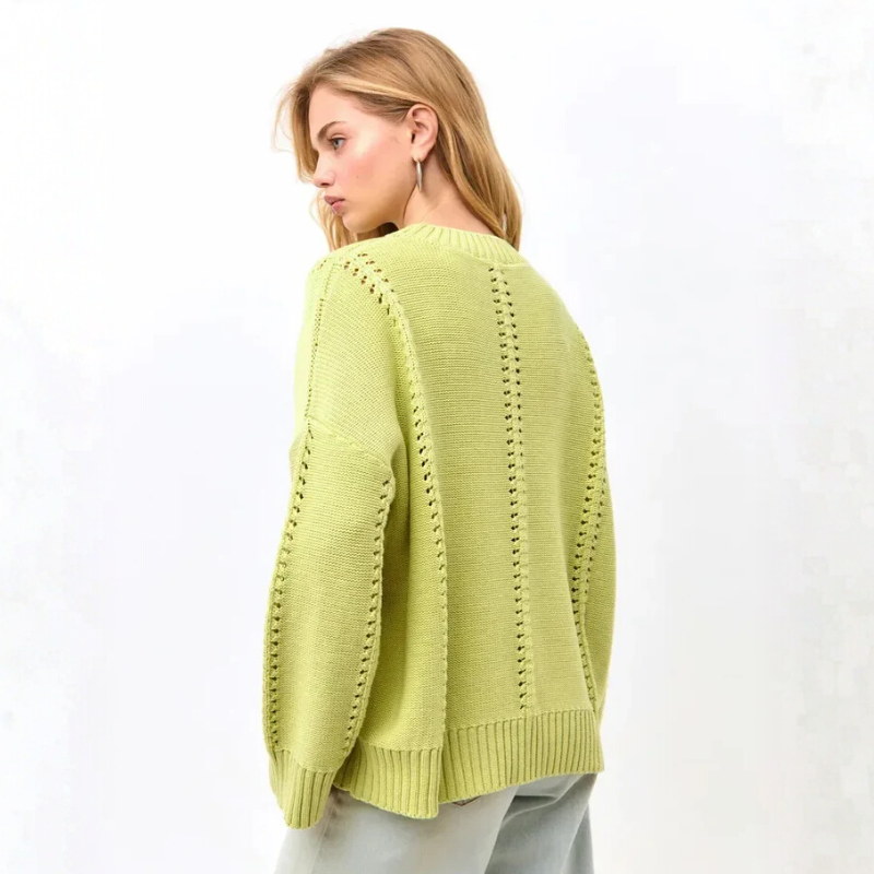 Woman wearing a light green sweater on a white background