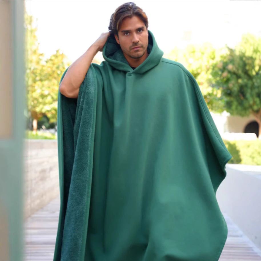 Man wearing a green hooded poncho outdoors