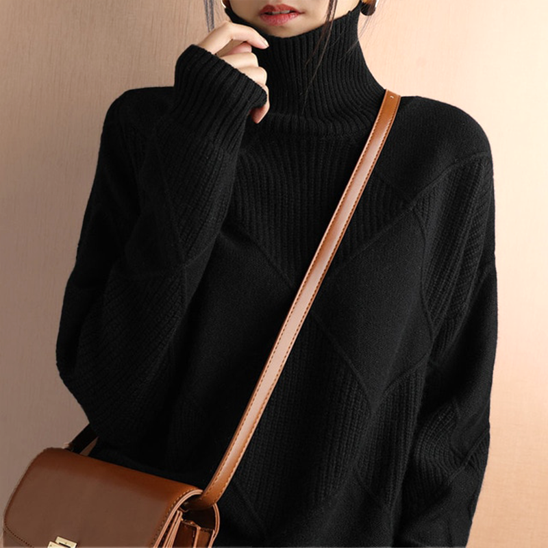 Person wearing a black turtleneck sweater with a brown crossbody bag