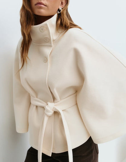 Beige coat with a belt worn by a person on a white background