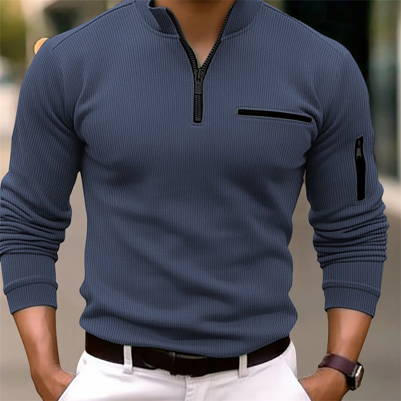 Blue long-sleeve shirt with zipper details worn by a person, blurred background