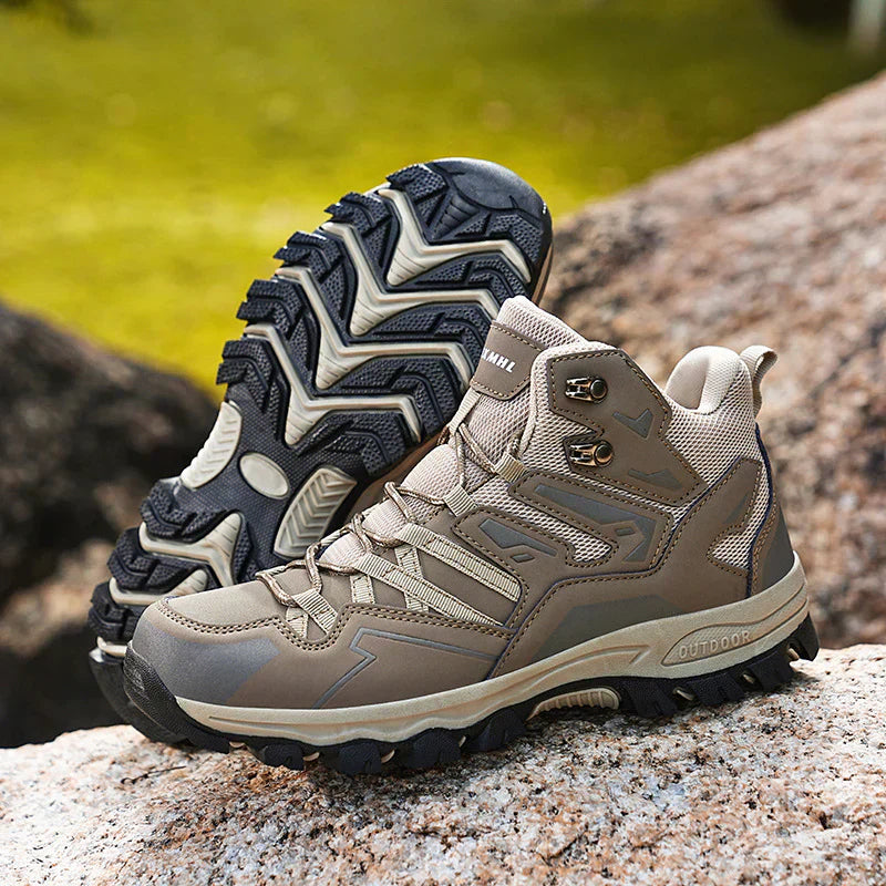 Pair of hiking boots on a natural rock surface with a blurred green background