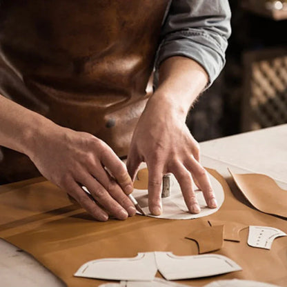 Person working with leather pieces on a table